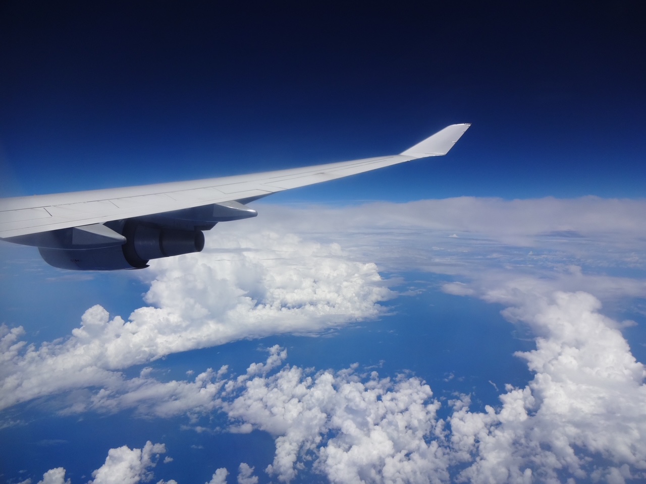 Eigene Reiseaufnahme: Flugzeugflügel über einem weiten Wolkenmeer